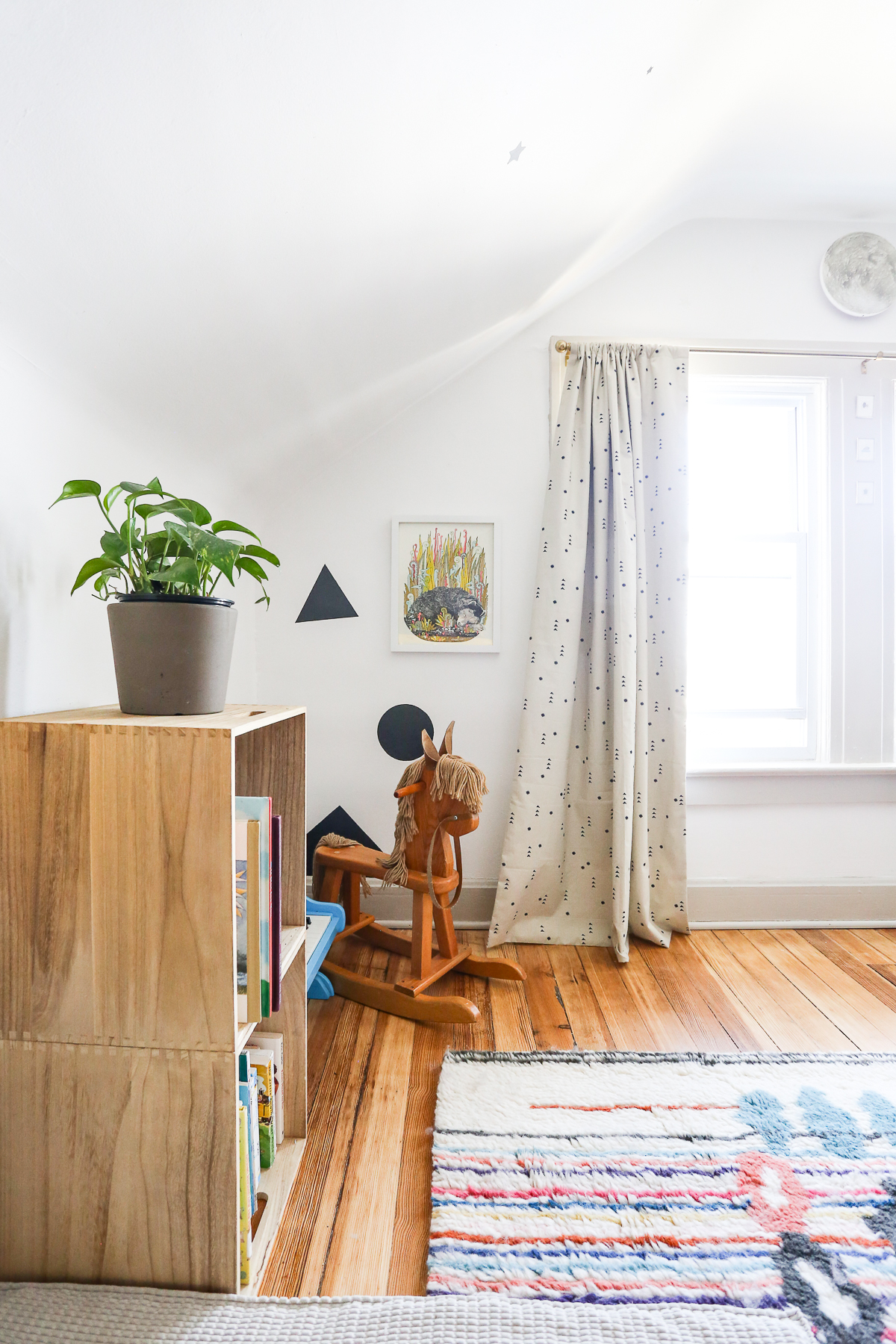 toddler room renovation reveal with wood floors, wool rug, and yellow metal bed